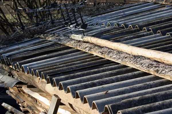 Plaques ondulées en fibrociment sur une toiture ancienne