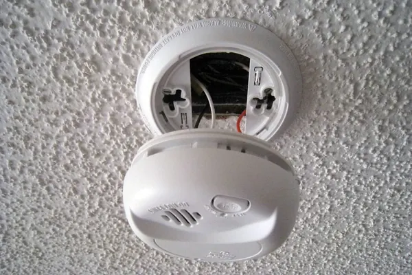 Détecteur de fumée fixé au plafond, capot ouvert