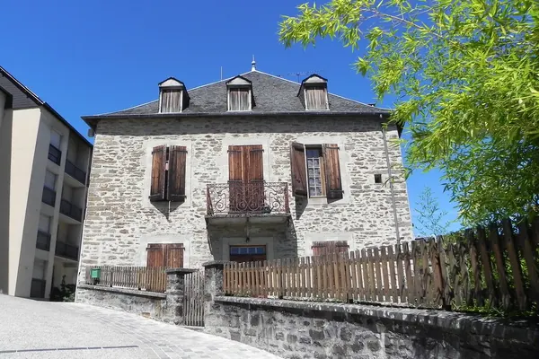 Maison ancienne en pierre aux volets de bois, à Uzerche (Corrèze)