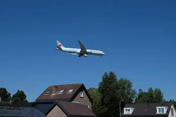 Avion de ligne en approche au-dessus de maisons, à Aalsmeer près de l’aéroport de Schiphol