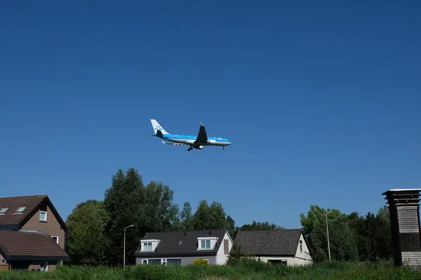 Avion de ligne à basse altitude au-dessus de maisons d’Aalsmeer, près de l’aéroport de Schiphol