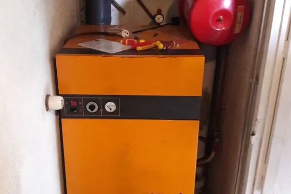 Ancienne chaudière au sol dans un local technique, avant son remplacement, dans le Tarn