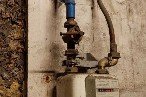 Compteur de gaz et canalisations dans le sous-sol d’un bâtiment parisien
